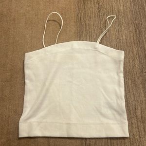 It has spaghetti straps and is white. It has been washed but never worn.